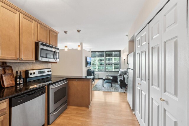 3600 N Lake Shore Dr Unit 517, Chicago, IL 60613 - kitchen featuring stainless steel appliances, a peninsula, dark countertops, and light wood-type flooring