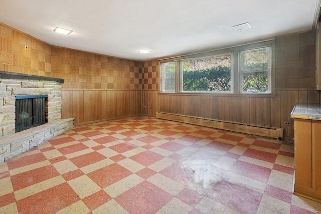 1214 Hull Ter, Evanston, IL 60202 - unfurnished living room with a baseboard heating unit, light floors, wooden walls, and a stone fireplace