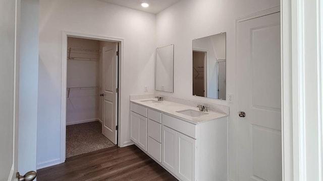 6467 Juniper Dr, Wonder Lake, IL 60097 - bathroom with wood finished floors, a walk in closet, double vanity, and baseboards