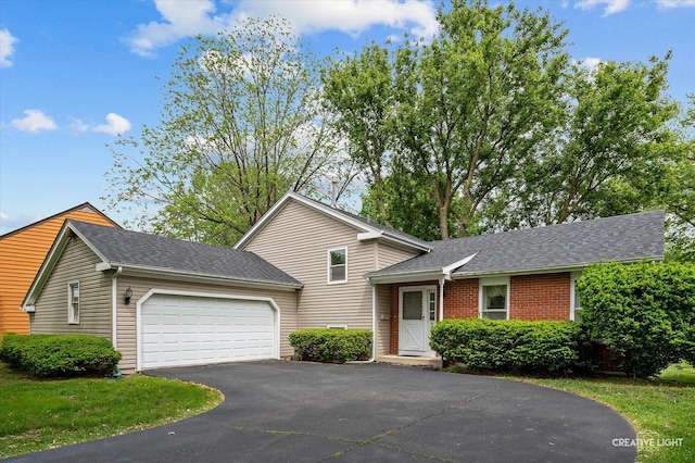 859 N Gladstone Ave, Aurora, IL 60506 - split level home with driveway, an attached garage, a shingled roof, and brick siding