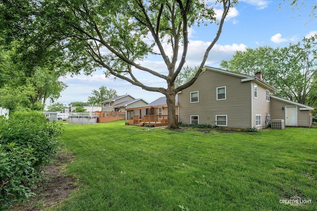 859 N Gladstone Ave, Aurora, IL 60506 - back of property featuring a chimney, central AC, a deck, and a yard