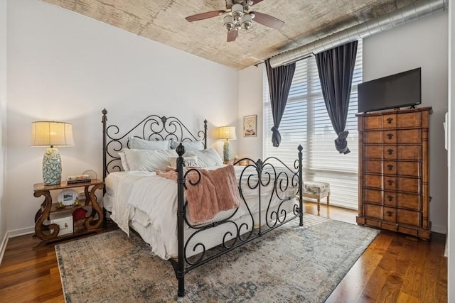 bedroom with wood finished floors, baseboards, and a ceiling fan