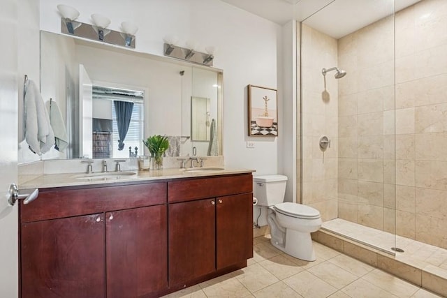bathroom featuring toilet, tiled shower, tile patterned floors, and double vanity
