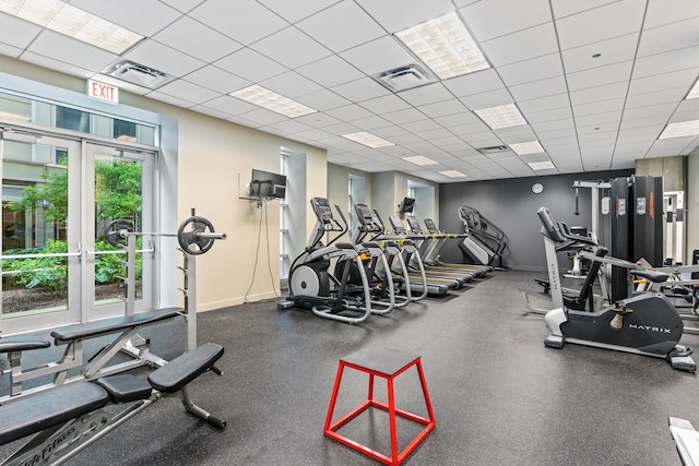 gym with baseboards and a drop ceiling