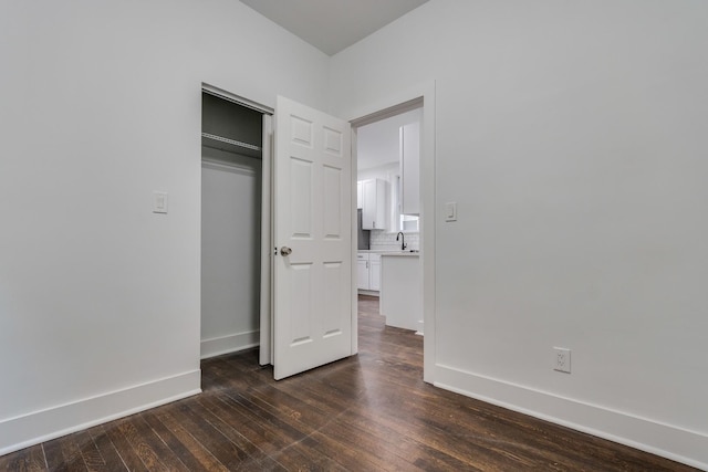 1922 Harvey Ave, Berwyn, IL 60402 - unfurnished bedroom featuring dark wood-style flooring, a sink, baseboards, and a closet