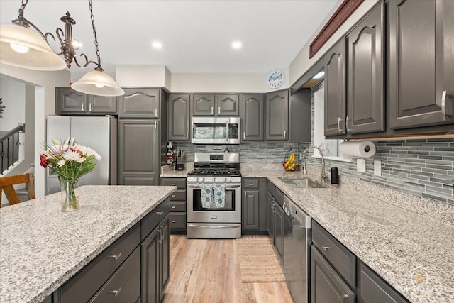 120 3 Oaks Rd, Cary, IL 60013 - kitchen featuring stainless steel appliances, a sink, gray cabinetry, tasteful backsplash, and light stone countertops