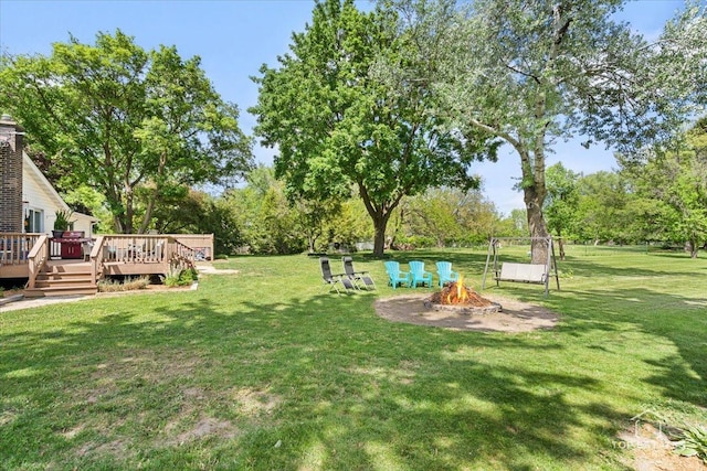 120 3 Oaks Rd, Cary, IL 60013 - view of grassy yard featuring an outdoor fire pit, a wooden deck, and view of wooded area