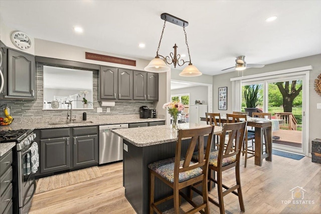 120 3 Oaks Rd, Cary, IL 60013 - kitchen featuring stainless steel appliances, a sink, tasteful backsplash, a breakfast bar area, and a ceiling fan