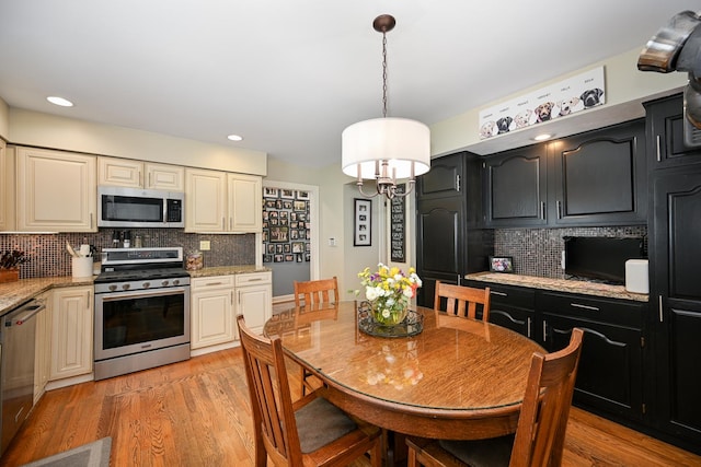 25W651 Towpath Ct, Wheaton, IL 60189 - kitchen with appliances with stainless steel finishes, backsplash, light wood-type flooring, dark cabinetry, and recessed lighting