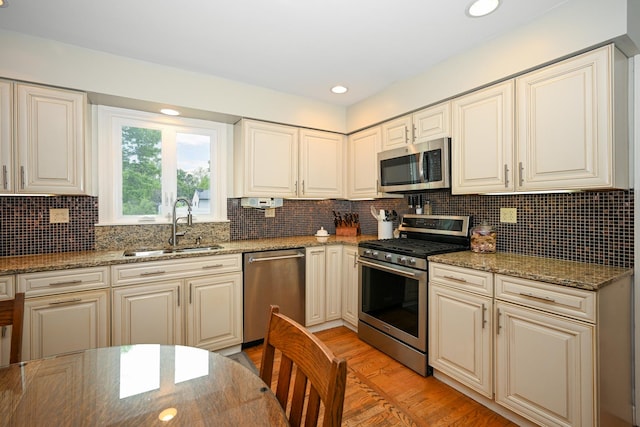 25W651 Towpath Ct, Wheaton, IL 60189 - kitchen with appliances with stainless steel finishes, a sink, light wood-style floors, stone counters, and decorative backsplash