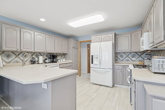 6719 W Applewood Ln, Spring Grove, IL 60081 - kitchen featuring white appliances, a sink, a peninsula, decorative backsplash, and gray cabinetry