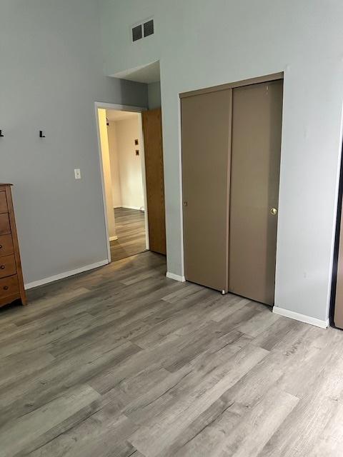 2302 Melrose Dr Unit A, Champaign, IL 61820 - unfurnished bedroom featuring light wood-style flooring, baseboards, a closet, and a high ceiling