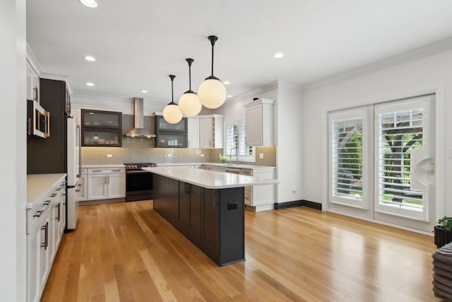 16829 Sheridans Trl, Orland Park, IL 60467 - kitchen with stainless steel appliances, wall chimney exhaust hood, a sink, light countertops, and ornamental molding