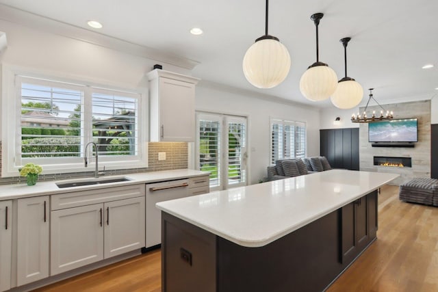 16829 Sheridans Trl, Orland Park, IL 60467 - kitchen featuring a sink, dishwasher, open floor plan, light countertops, and ornamental molding