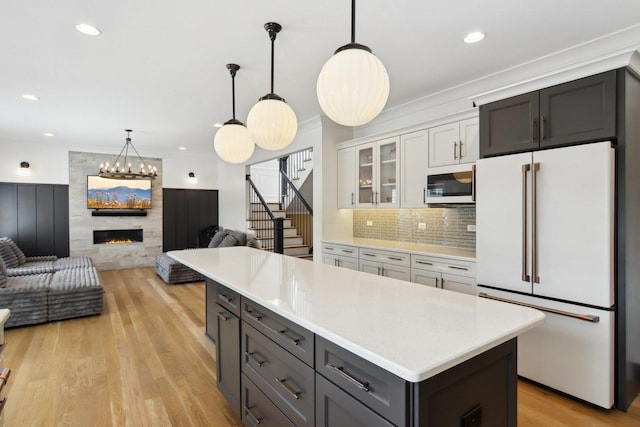 16829 Sheridans Trl, Orland Park, IL 60467 - kitchen featuring white appliances, open floor plan, light countertops, a fireplace, and glass insert cabinets