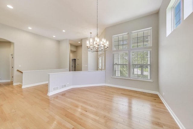 2334 Glen Eagles Ln, Riverwoods, IL 60015 - spare room featuring a chandelier, arched walkways, light wood-type flooring, plenty of natural light, and recessed lighting