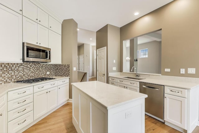 2334 Glen Eagles Ln, Riverwoods, IL 60015 - kitchen featuring appliances with stainless steel finishes, a sink, a center island, backsplash, and white cabinets