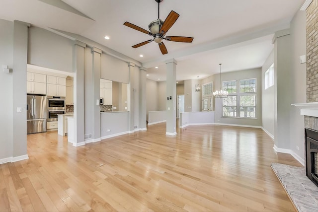 2334 Glen Eagles Ln, Riverwoods, IL 60015 - unfurnished living room featuring a glass covered fireplace, ceiling fan, light wood-type flooring, recessed lighting, and a chandelier