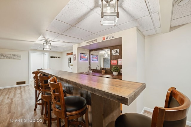 238 1st St, Cary, IL 60013 - indoor wet bar with a drop ceiling, baseboards, and light wood-style floors