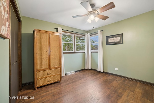 238 1st St, Cary, IL 60013 - unfurnished bedroom featuring dark wood finished floors, baseboards, and a ceiling fan