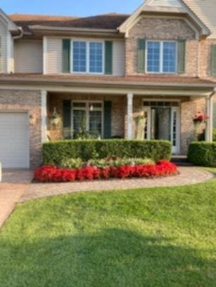 5355 Fox Path Ln, Hoffman Estates, IL 60192 - view of front of home with driveway, a front lawn, an attached garage, and covered porch