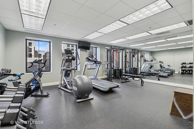 gym featuring a drop ceiling and baseboards