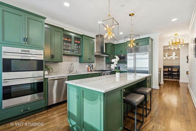 kitchen with green cabinets, built in appliances, a chandelier, backsplash, and ornamental molding