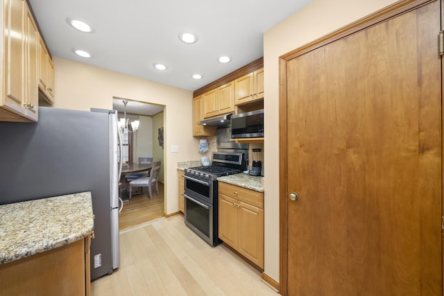 4129 N Mcvicker Ave, Chicago, IL 60634 - kitchen featuring stainless steel appliances, under cabinet range hood, light wood-style flooring, recessed lighting, and light stone countertops
