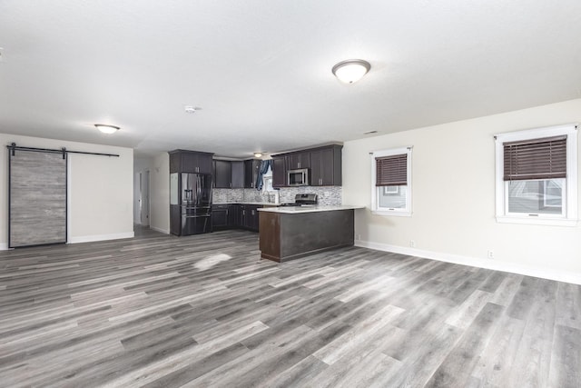 1614 Poplar St, Ottawa, IL 61350 - kitchen with stainless steel appliances, open floor plan, a barn door, light countertops, and baseboards