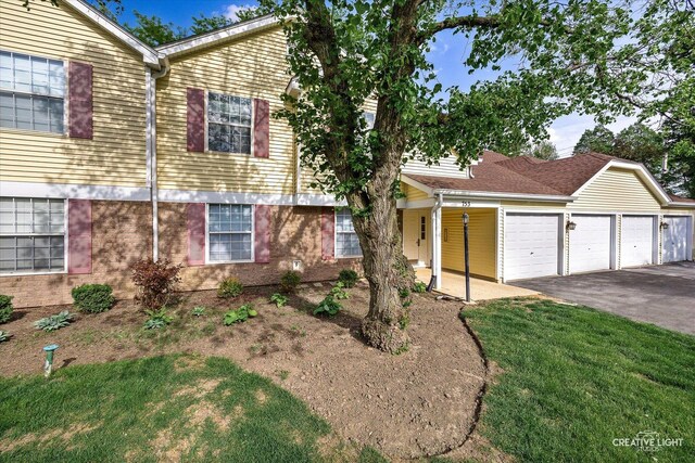 753 Candleridge Ct Unit C1, Bartlett, IL 60103 - view of front of home featuring an attached garage, driveway, a front yard, a porch, and brick siding