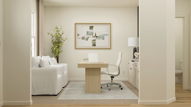office space featuring baseboards and light wood finished floors
