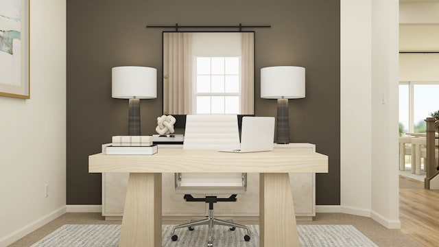 office area with baseboards, plenty of natural light, and light carpet
