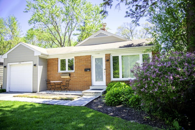 1703 Beverly Pl, Highland Park, IL 60035 - view of front of house featuring a garage, brick siding, driveway, and a front lawn