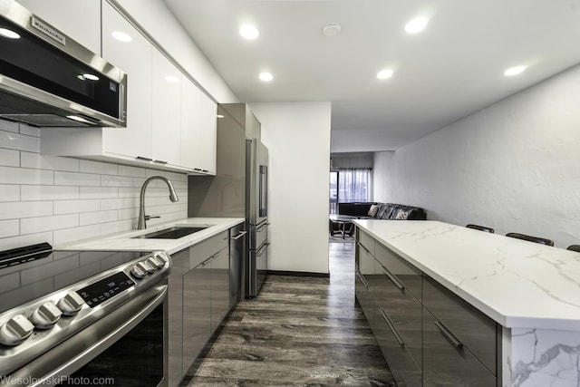 1296 E Washington St Unit 11, Des Plaines, IL 60016 - kitchen with appliances with stainless steel finishes, a sink, modern cabinets, tasteful backsplash, and white cabinets