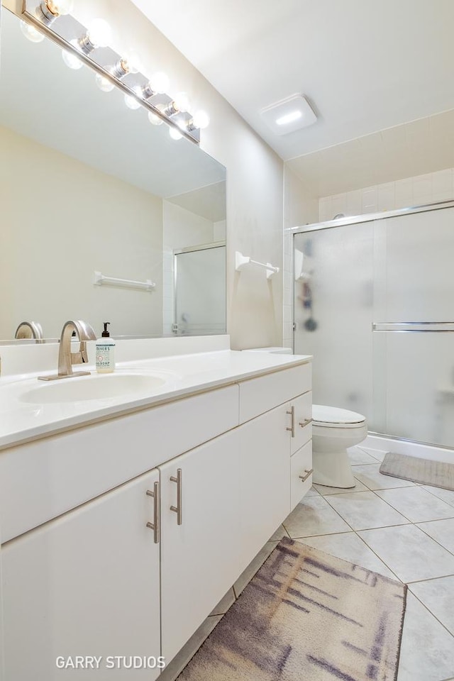 926 Willow St, Itasca, IL 60143 - bathroom featuring a shower stall, vanity, toilet, and tile patterned floors