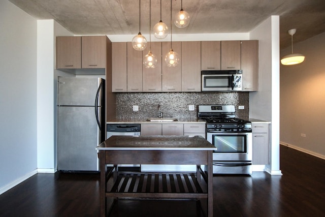 kitchen featuring appliances with stainless steel finishes, dark wood-style floors, a sink, and backsplash