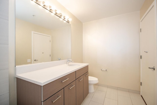 bathroom featuring vanity, toilet, tile patterned flooring, and baseboards