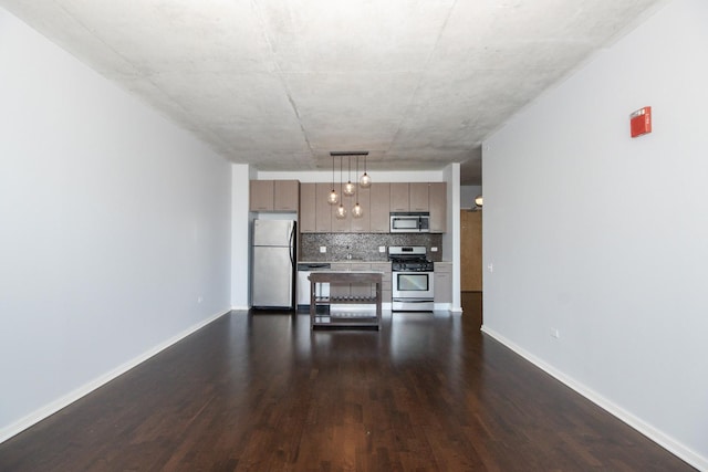 kitchen featuring appliances with stainless steel finishes, light countertops, dark wood-style floors, tasteful backsplash, and open floor plan