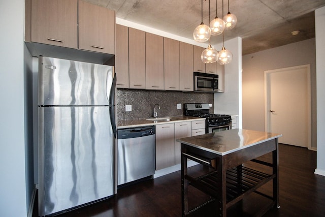 kitchen with stainless steel appliances, a sink, dark wood-type flooring, and tasteful backsplash