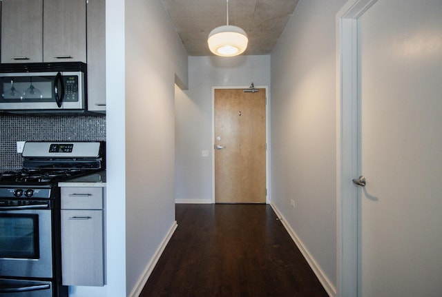 hallway featuring dark wood-style floors and baseboards