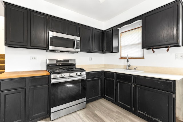 8639 Plainfield Rd, Lyons, IL 60534 - kitchen featuring stainless steel appliances, dark cabinets, and light wood finished floors