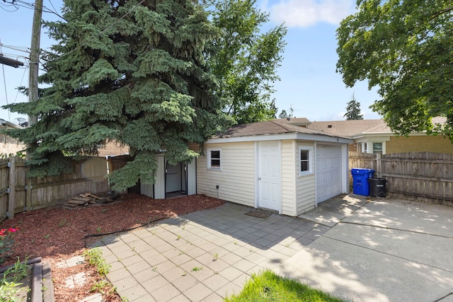 8639 Plainfield Rd, Lyons, IL 60534 - back of property featuring an outdoor structure, concrete driveway, a fenced backyard, and a garage