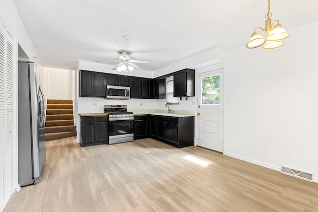 8639 Plainfield Rd, Lyons, IL 60534 - kitchen with stainless steel appliances, dark cabinetry, light wood finished floors, light countertops, and a ceiling fan
