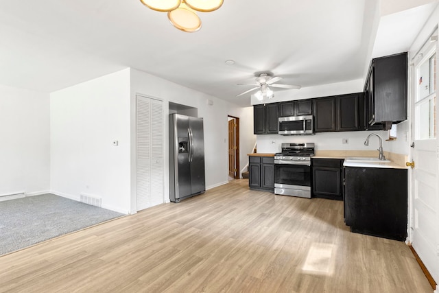 8639 Plainfield Rd, Lyons, IL 60534 - kitchen with stainless steel appliances, dark cabinets, light countertops, light wood-style floors, and a ceiling fan