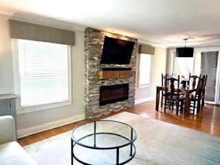 1010 N Patton Ave, Arlington Heights, IL 60004 - living area featuring wood finished floors, a fireplace, healthy amount of natural light, baseboards, and crown molding