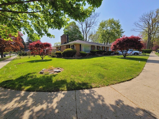 511 N Berwick Blvd, Waukegan, IL 60085 - view of front of home featuring a chimney, a front lawn, and brick siding