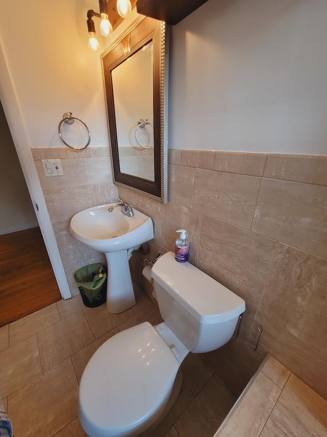 511 N Berwick Blvd, Waukegan, IL 60085 - bathroom featuring tile walls, toilet, tile patterned flooring, wainscoting, and a sink