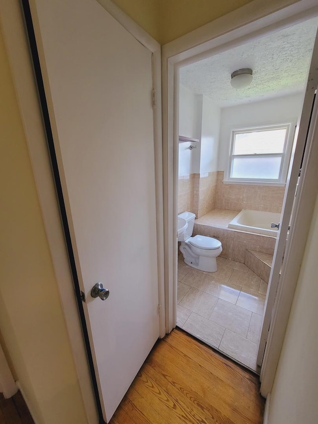 511 N Berwick Blvd, Waukegan, IL 60085 - bathroom featuring toilet, tiled tub, and tile patterned floors