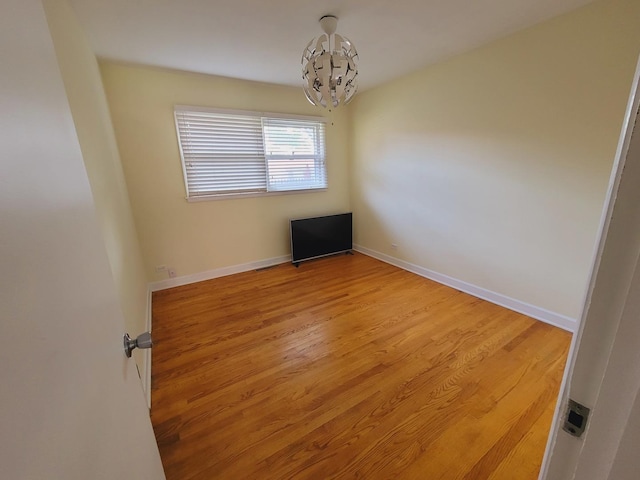 511 N Berwick Blvd, Waukegan, IL 60085 - empty room featuring a chandelier, wood finished floors, and baseboards