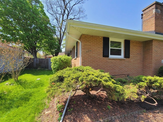 511 N Berwick Blvd, Waukegan, IL 60085 - view of property exterior featuring a chimney, brick siding, and fence